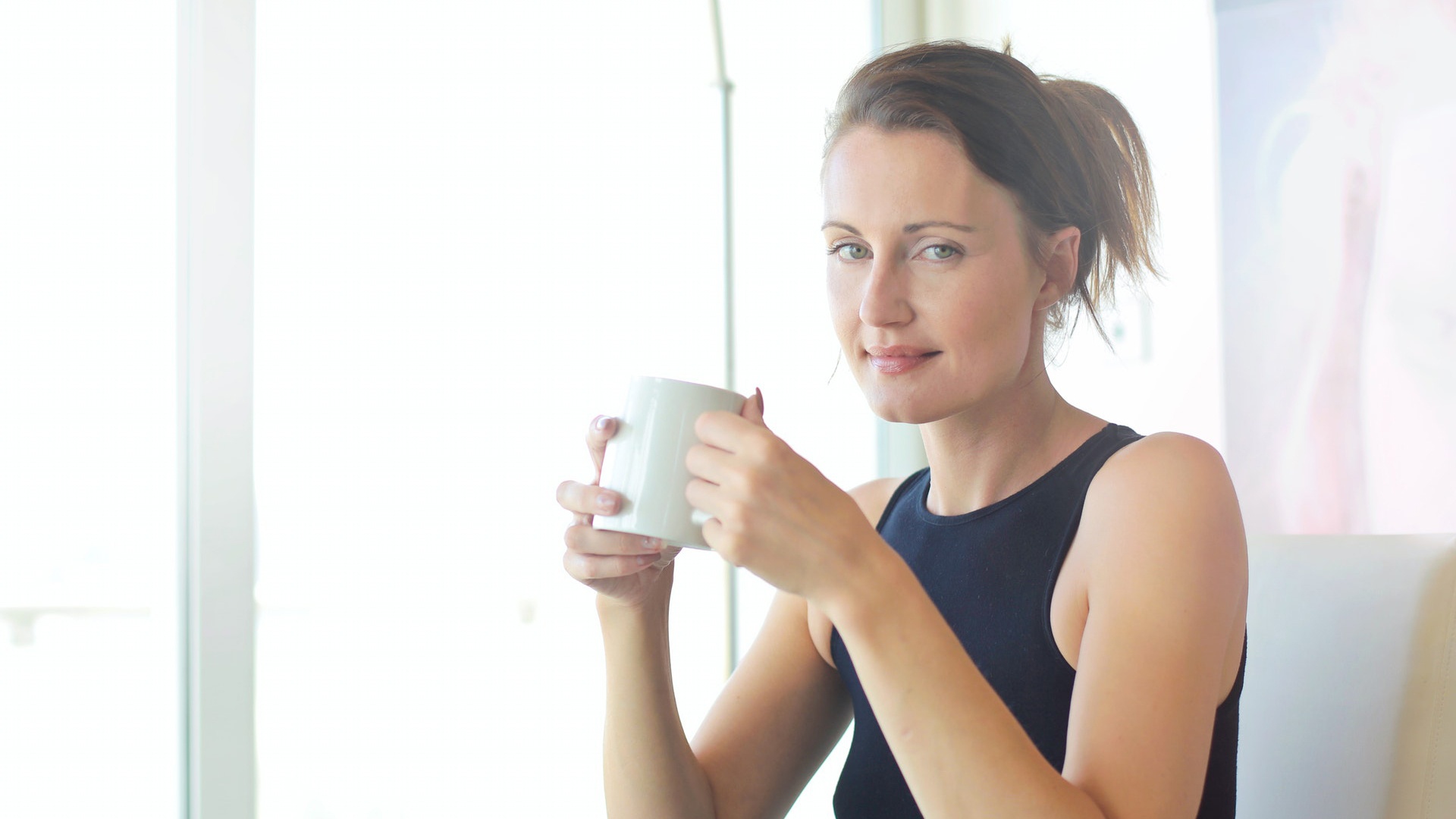 confident woman in black drinking coffee after information sharing with business partners