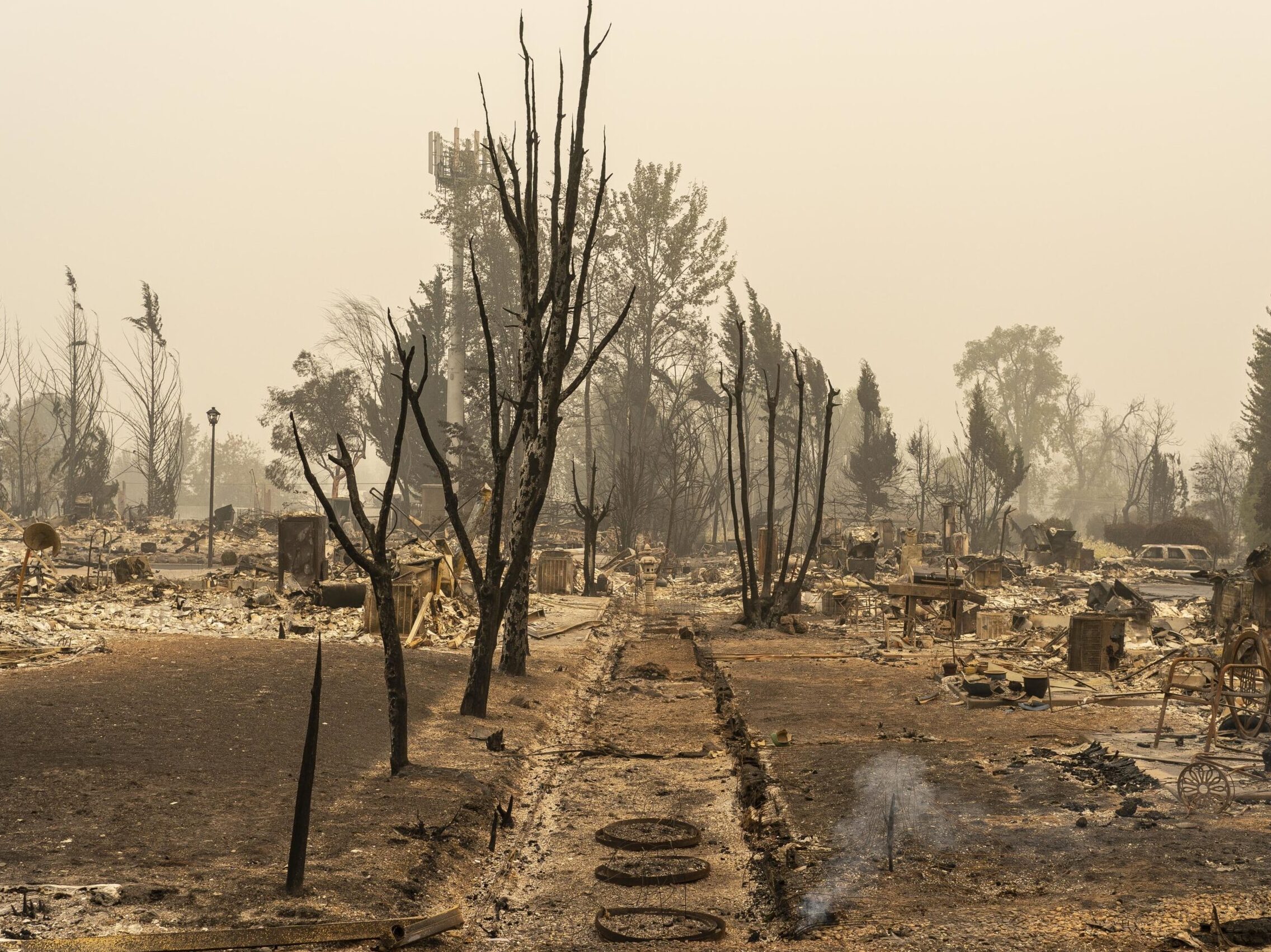 TALENT, OR - SEPTEMBER 13: Smoke rises from the ground in a neighborhood destroyed by wildfire on September 13, 2020 in Talent, Oregon. Hundreds of homes in Talent and nearby towns have been lost due to wildfire. (Photo by David Ryder/Getty Images)